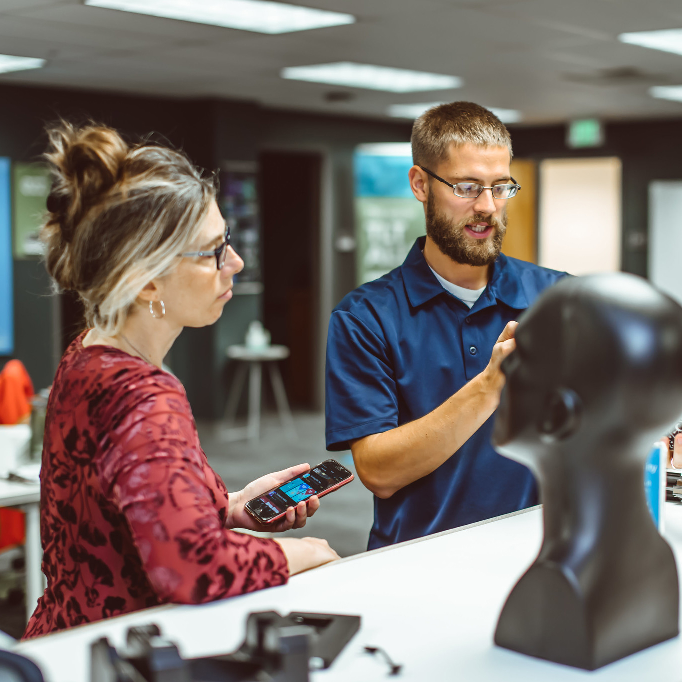 TLT staffer shows an instructor how to use AR and VR tools at a community meeting